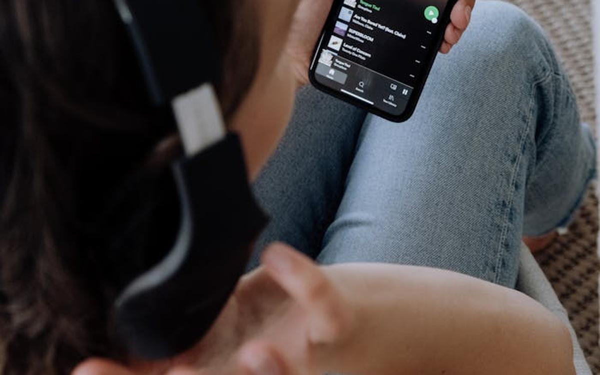 A woman relaxing and listening to a Spotify playlist, discovering new music to share with friends using TuneTandem.